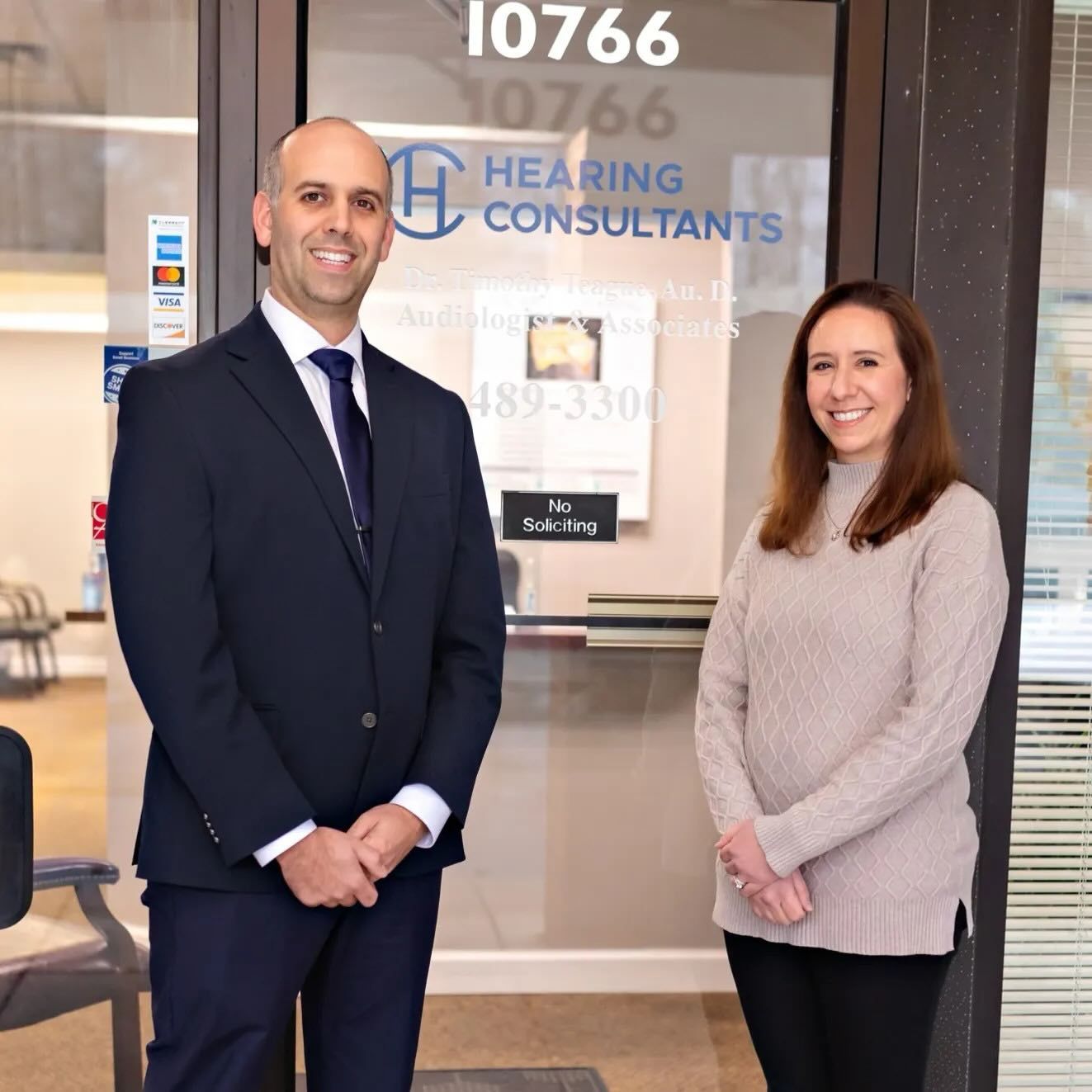 Two Hearing Consultants team members standing at the entrance of the Cincinnati office