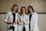 Three Ears4U Hearing Services audiologists in white coats, one holding headphones