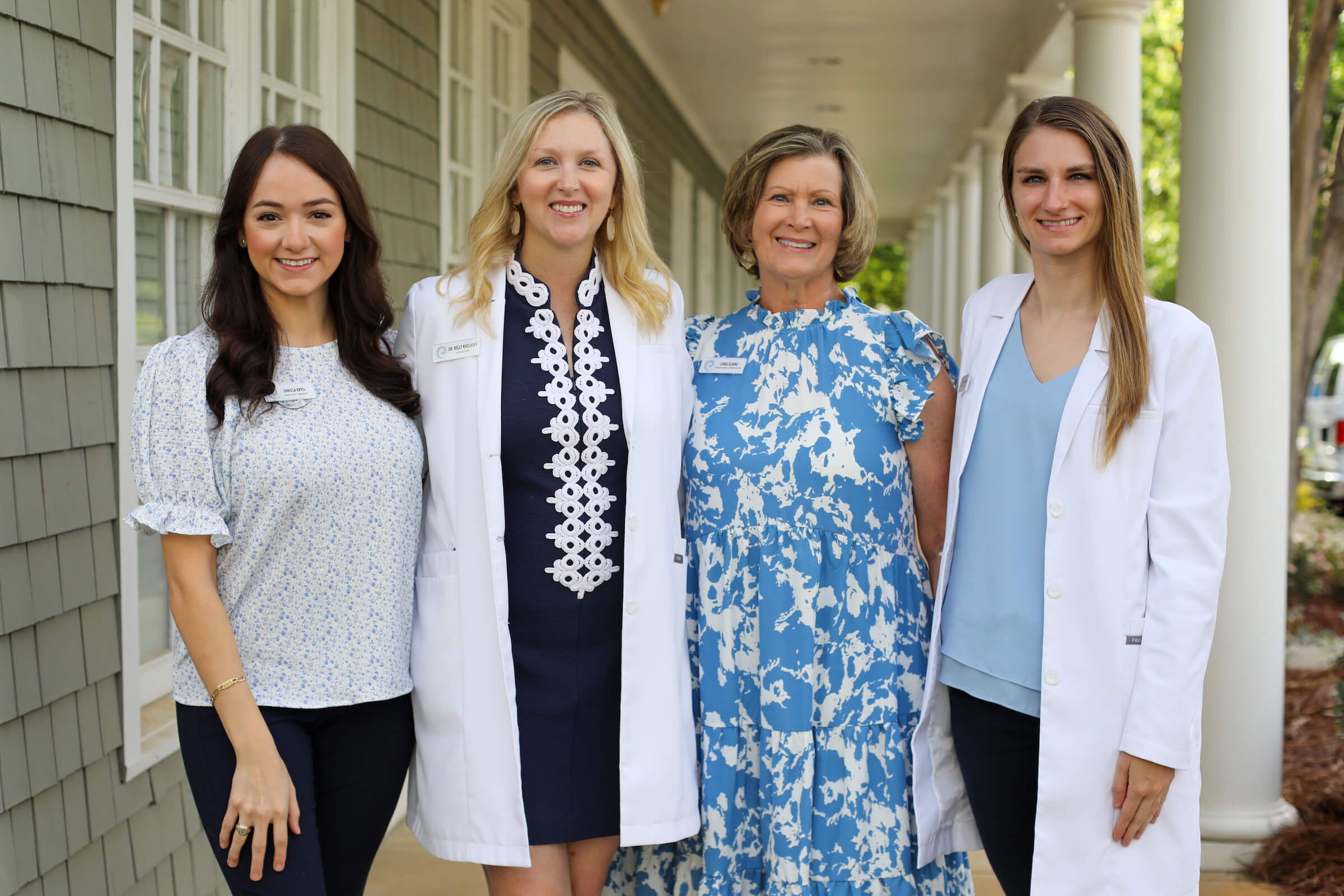 Four members of the Birkdale Audiology team standing on the office porch