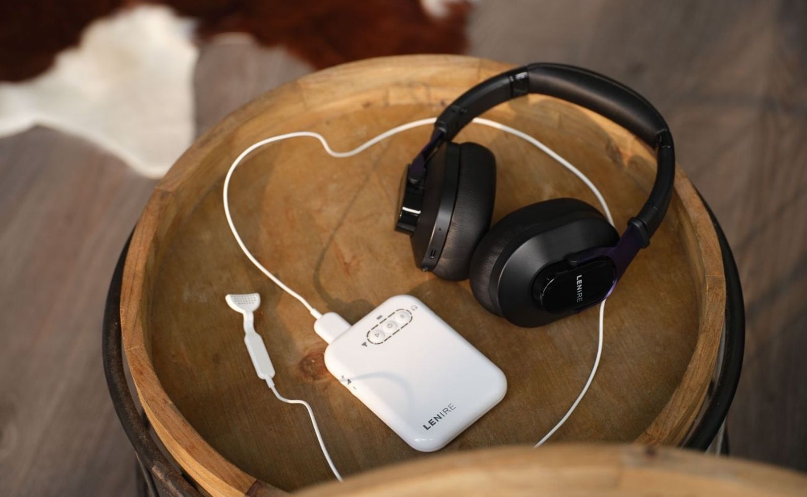 The Lenire device on a wooden tabletop: headphones, a white handheld controller and a small tongue piece