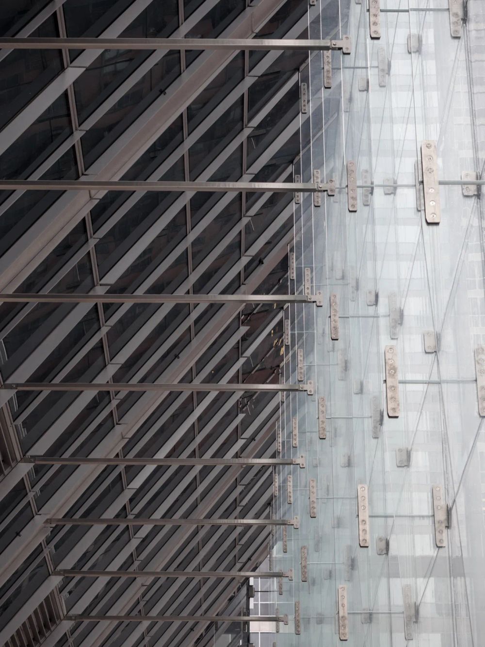 Diagonal steel bracing meeting a pale concrete wall