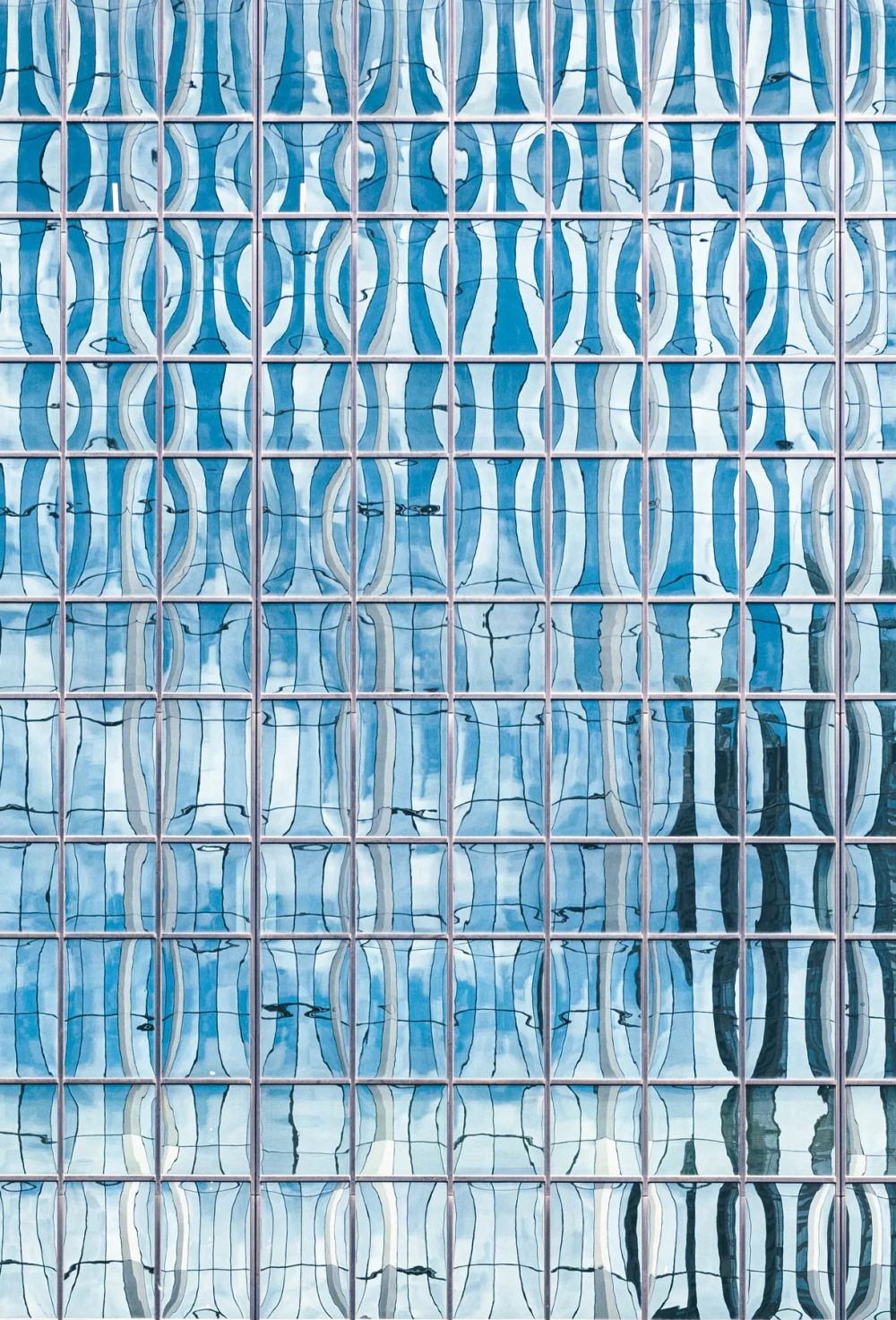 Repeating curved blue glazing creating a rippling pattern across a tower