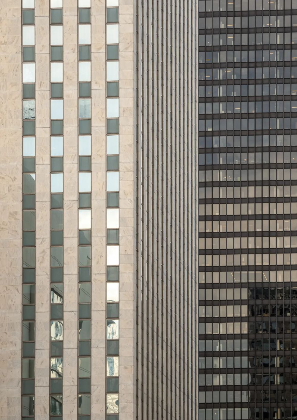Pale stone window strips beside a dark neighboring high-rise facade