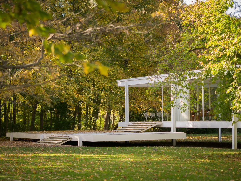 A glass pavilion surrounded by autumn trees