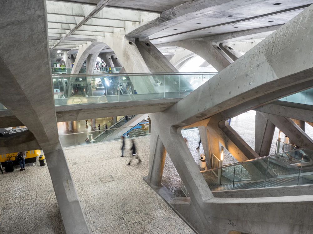 Concrete diagonal beams and glass bridges crossing an occupied atrium