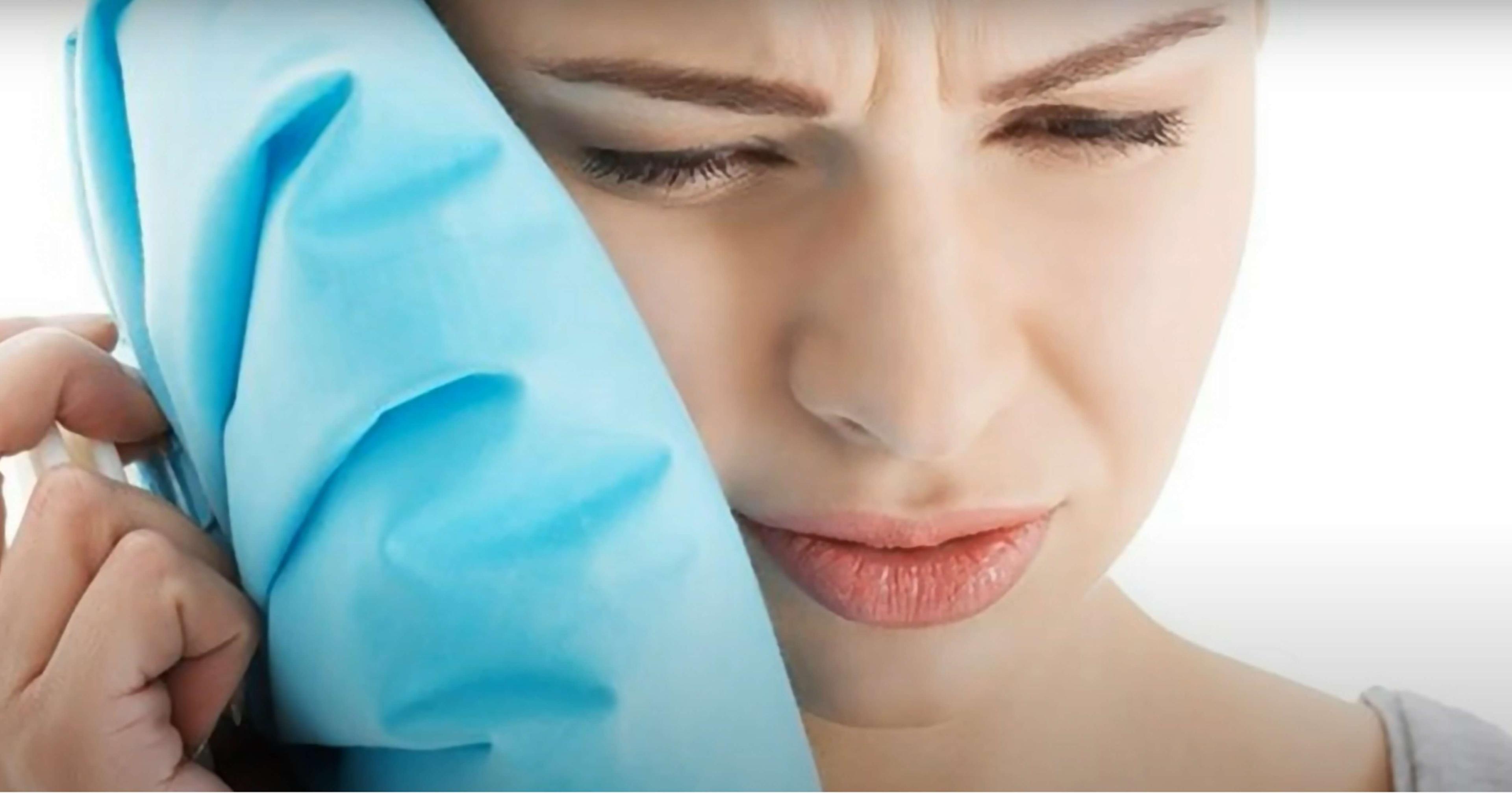 Woman pressing a cold pack to her cheek