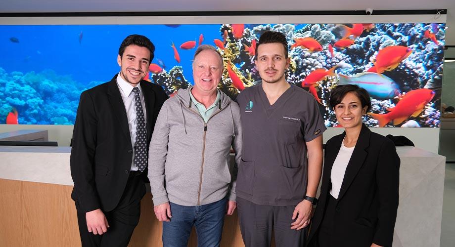 Four people standing in front of a screen showing fish