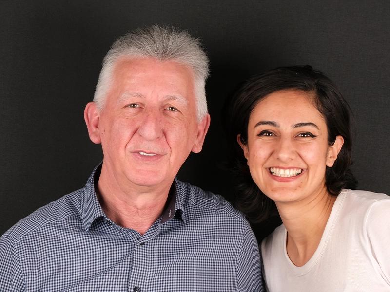 Studio portrait of an older man and a younger woman smiling