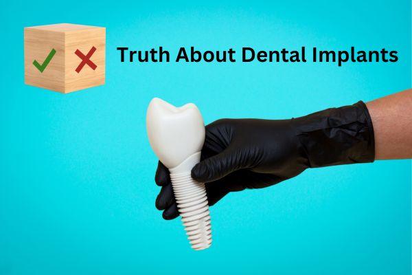 Gloved hand holding a model dental implant with crown
