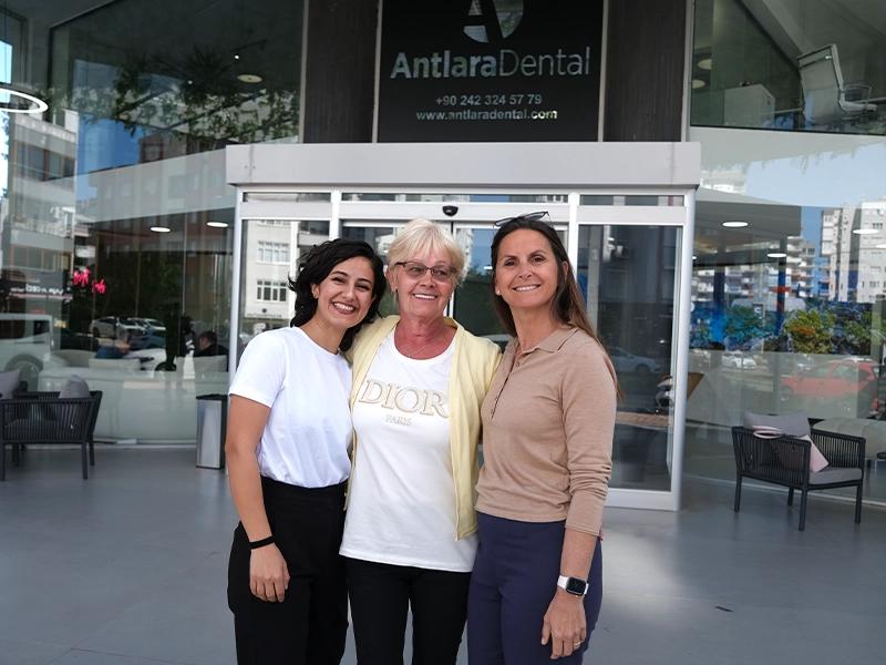 Three patients smiling at the clinic entrance