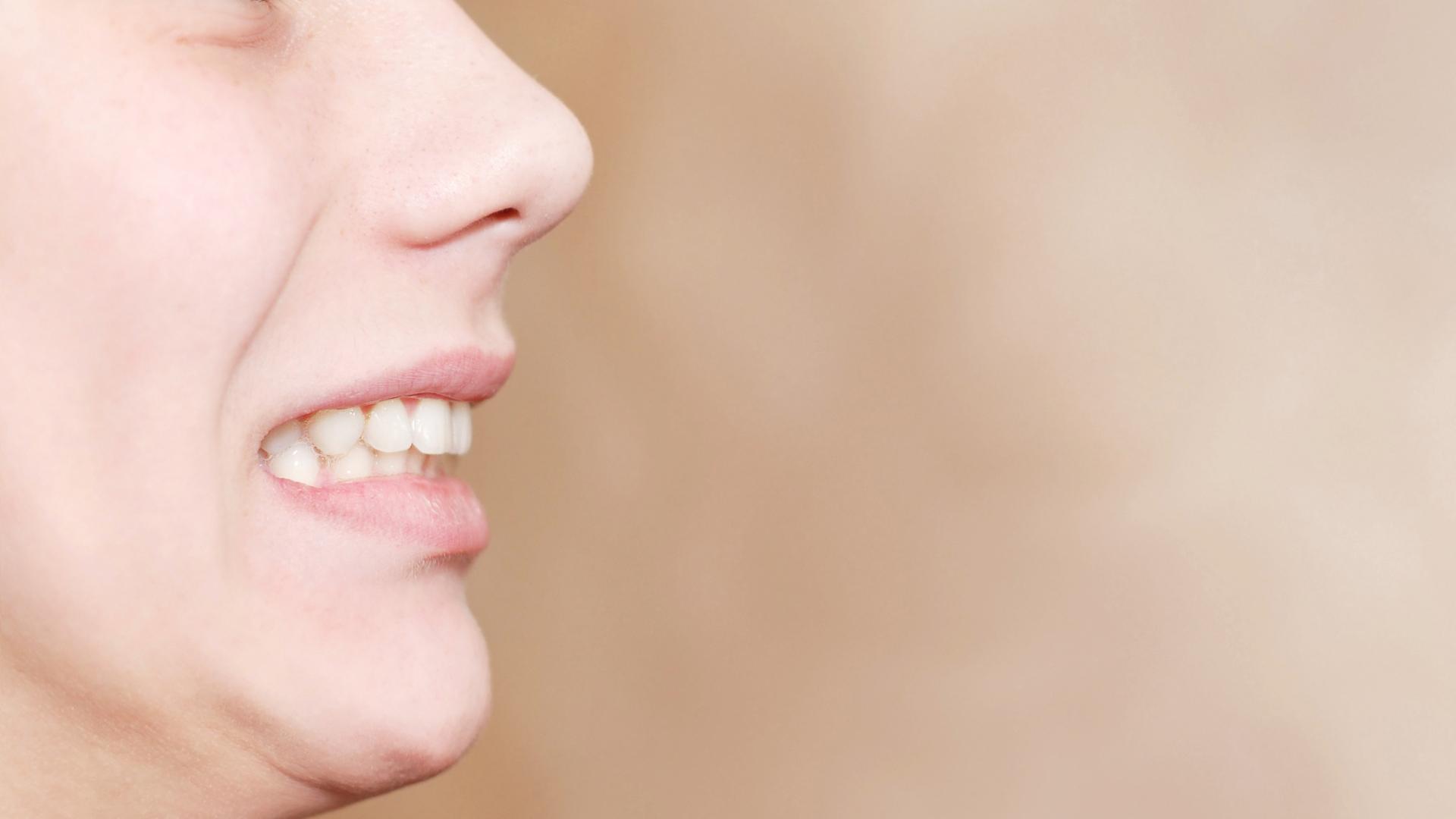 Side profile of a person smiling with upper and lower teeth