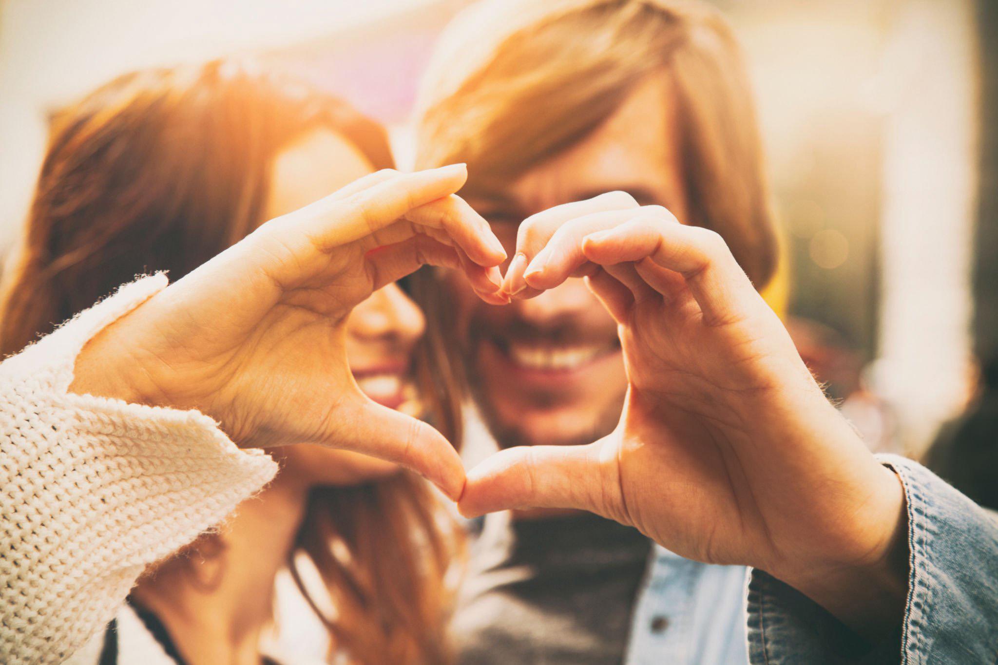 Couple making a heart shape with their hands