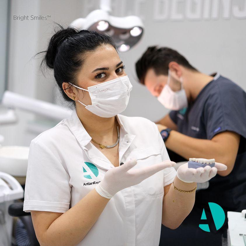Clinic staff member holding a dental model in a treatment room