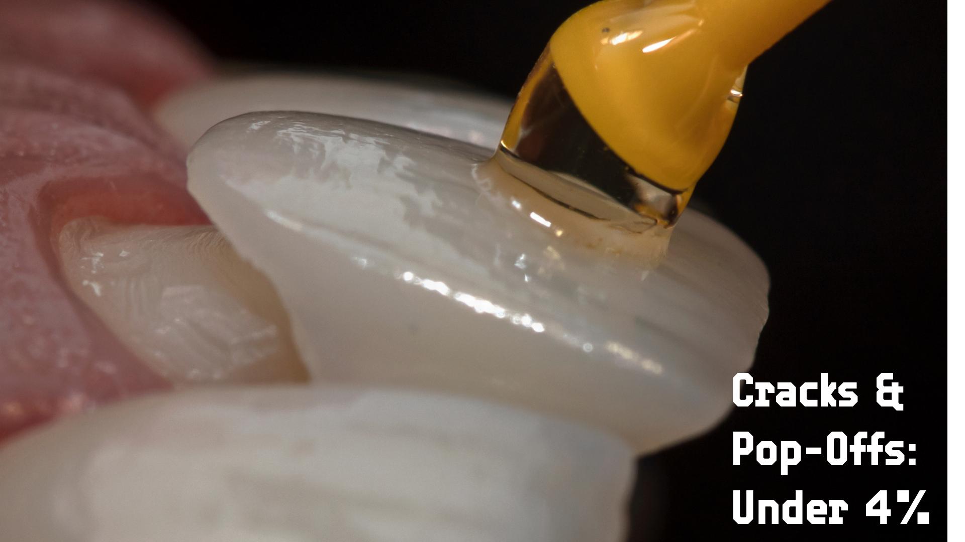 Close-up of a porcelain veneer being bonded to a tooth with a yellow applicator
