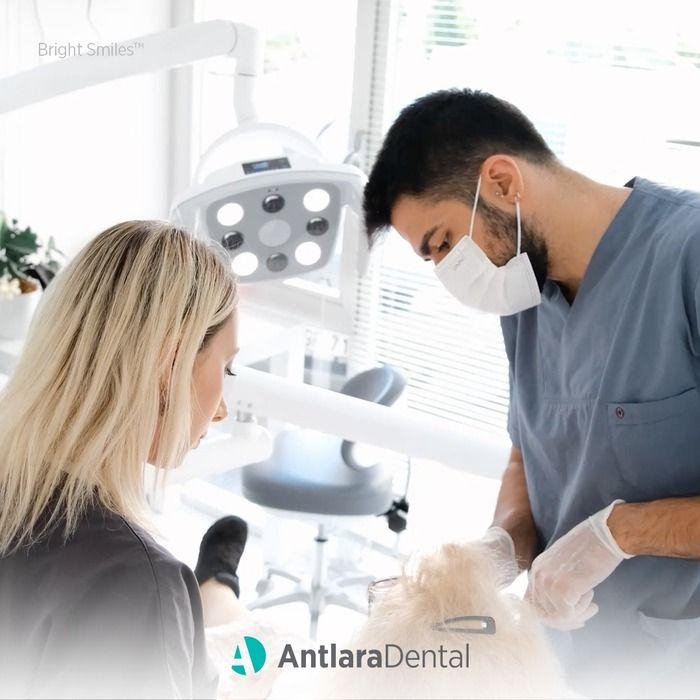 Dentist working at a patient in a bright treatment room