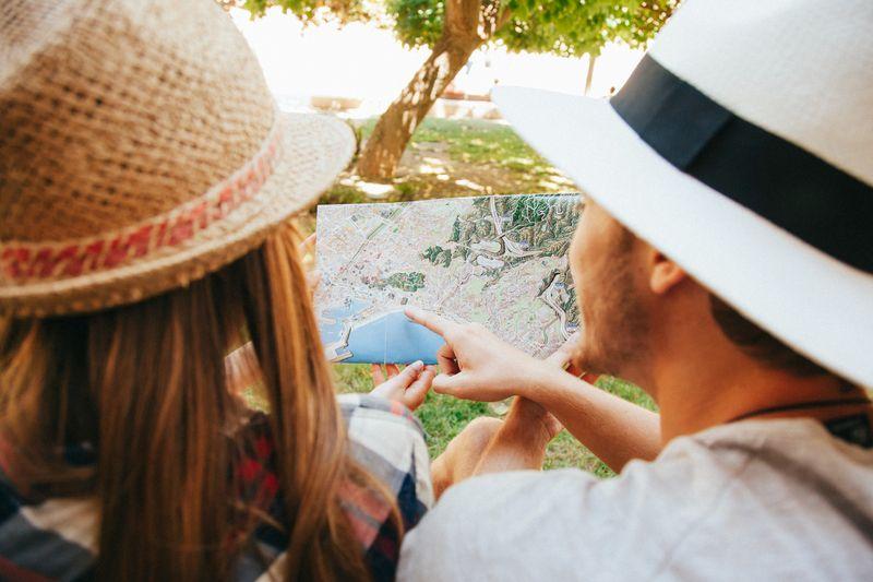 Two travellers in hats looking at a map