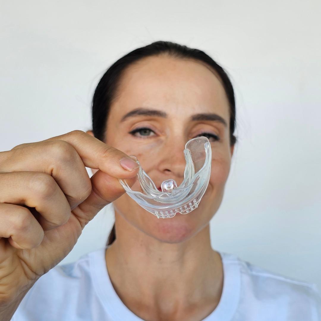 Woman holding a clear mouth guard