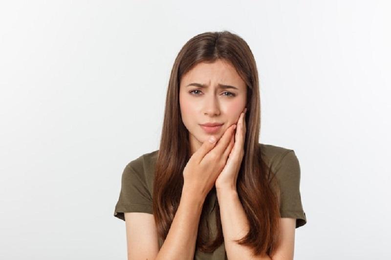 Woman holding her cheek in pain