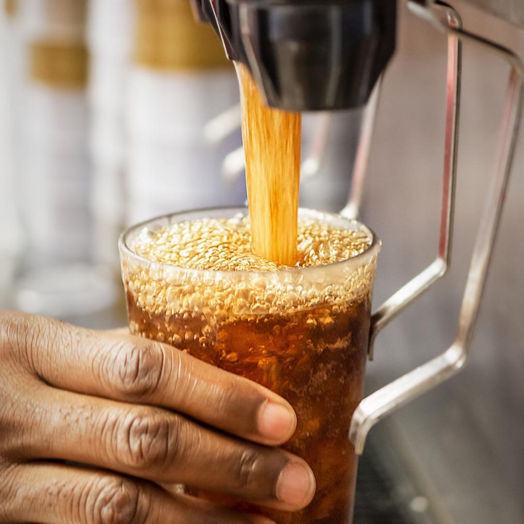 Soda pouring from a dispenser into a glass