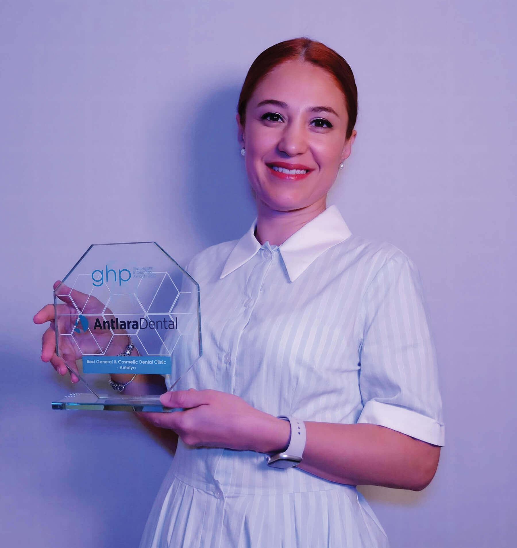 Dentist holding a glass award plaque