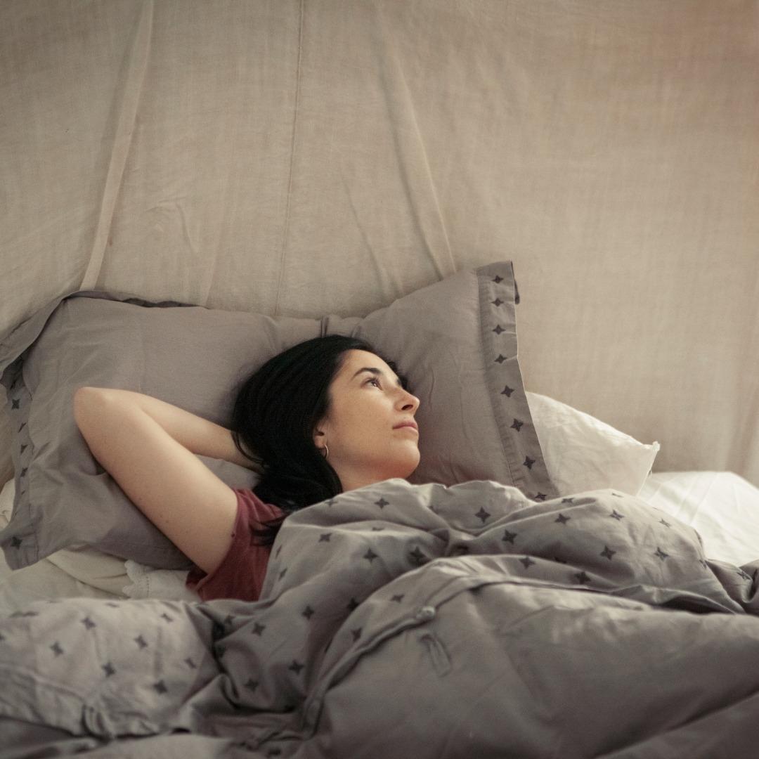 Woman lying in bed on pillows