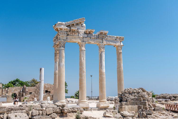 Ancient stone columns of a temple under a blue sky