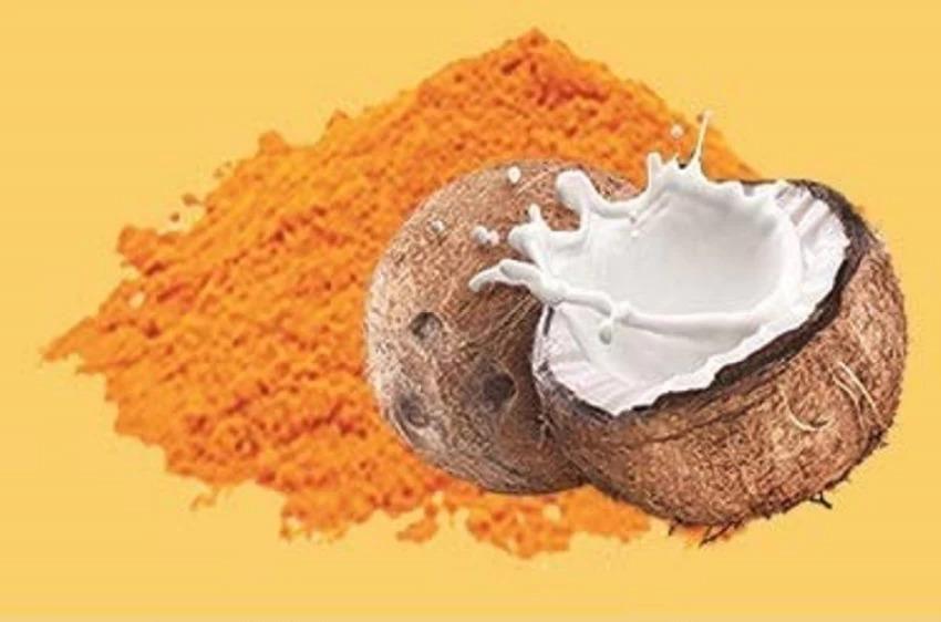 Turmeric powder beside a split coconut