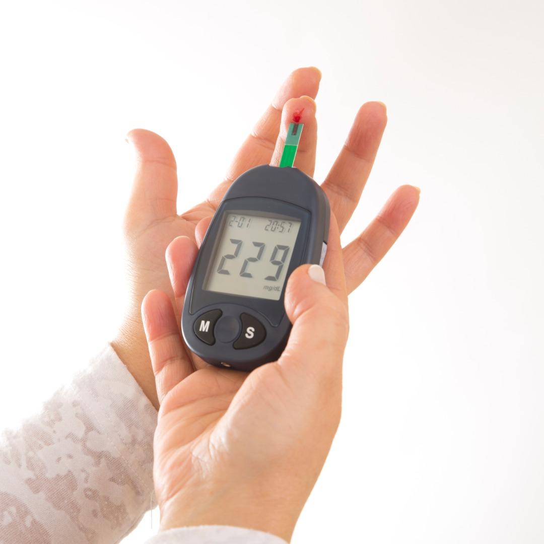 Hands using a blood glucose meter