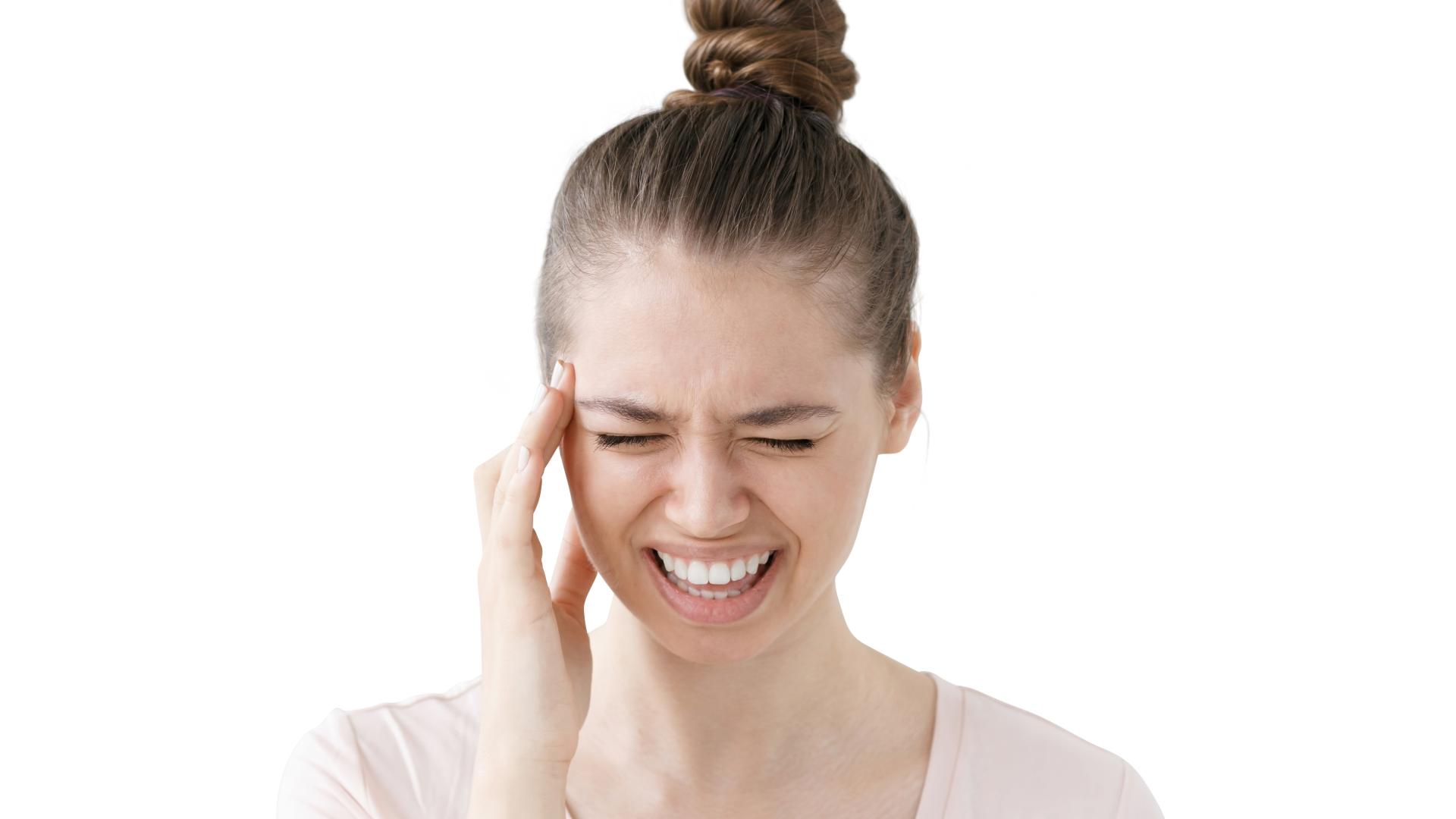 Woman pressing her temple with a pained expression
