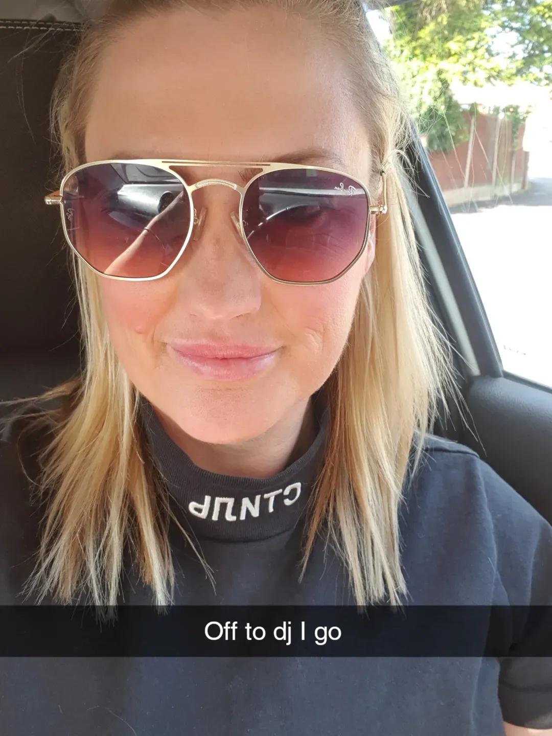 Woman in sunglasses taking a selfie in a car