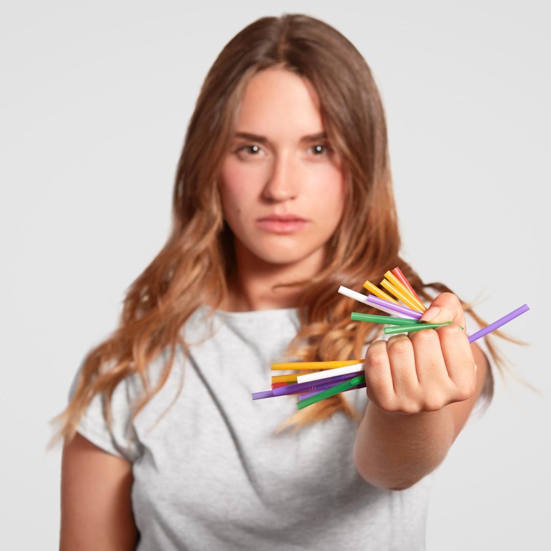 Young woman holding a handful of drinking straws