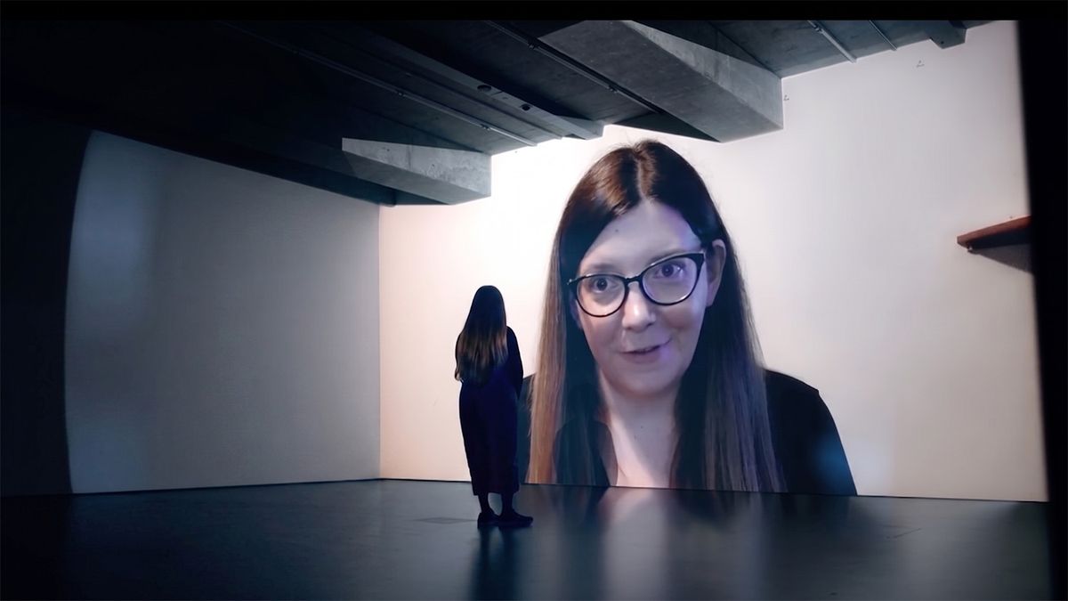 Women looking at a projection of herself on the wall