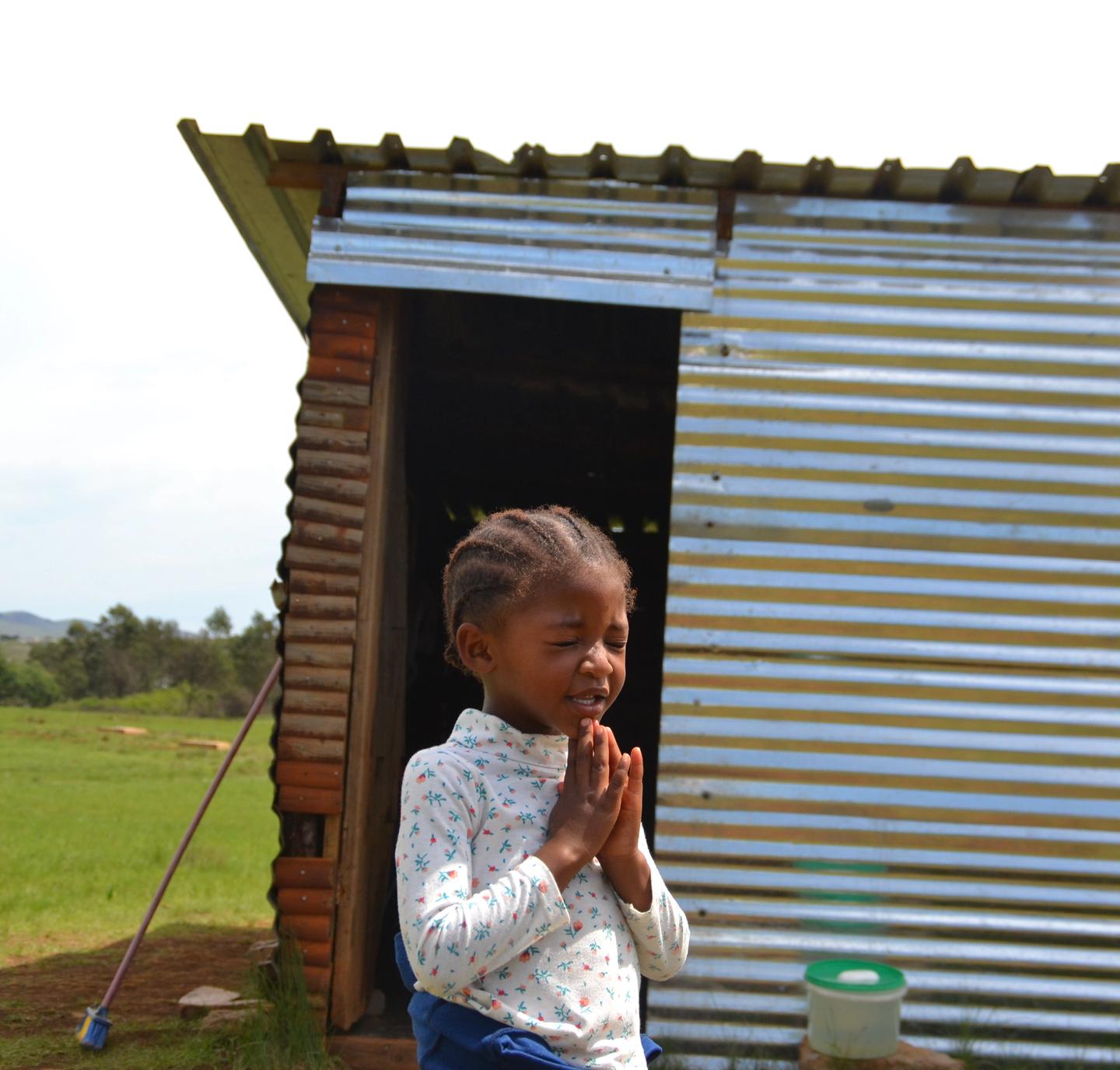 barn som står foran blikk skur barnehage i Sør Afrika