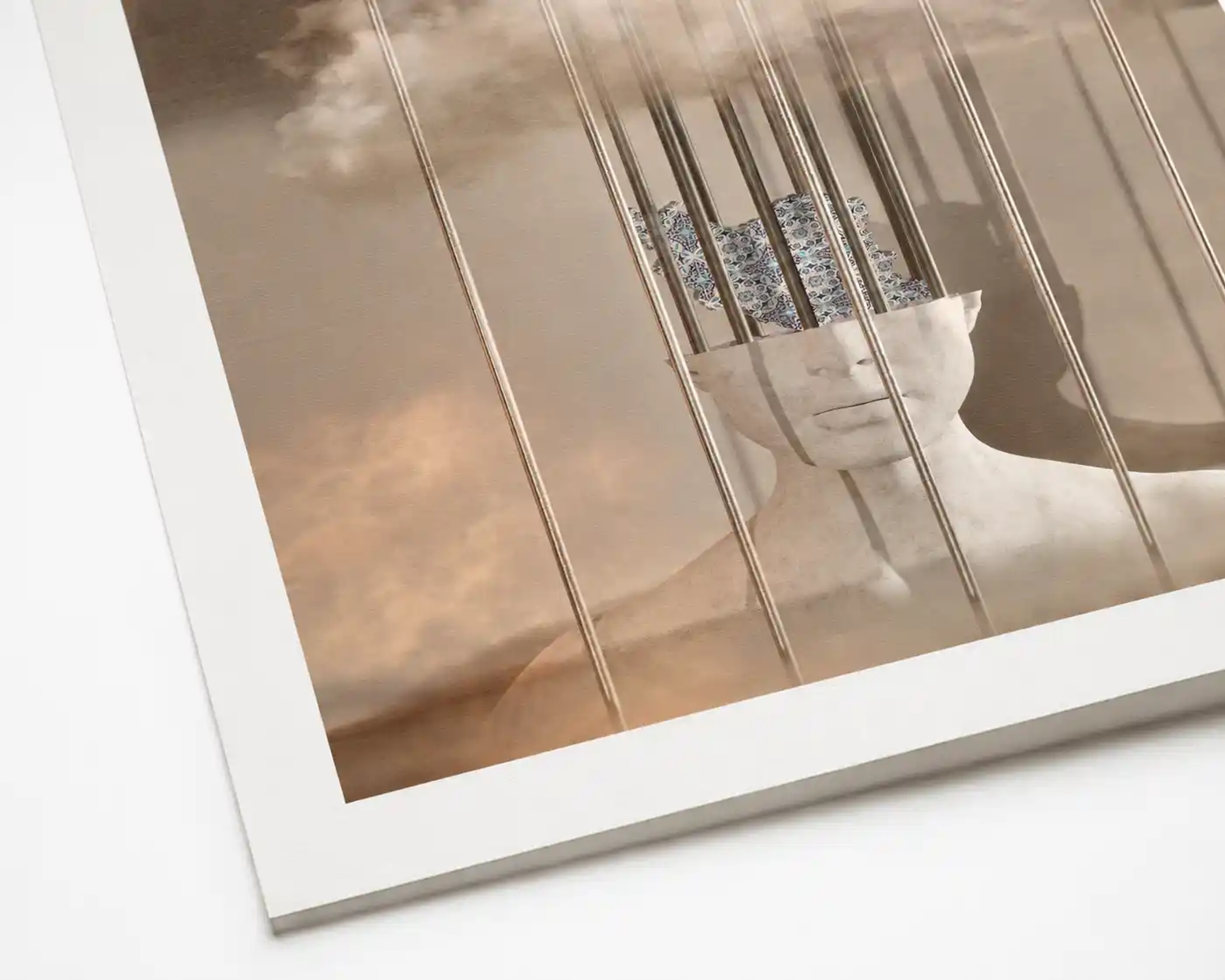 A digital mixed media artwork featuring a white sculpture of a human bust behind thin metal bars. The top of the head is open, revealing a patterned map of Iran inside, surrounded by soft clouds and mist.