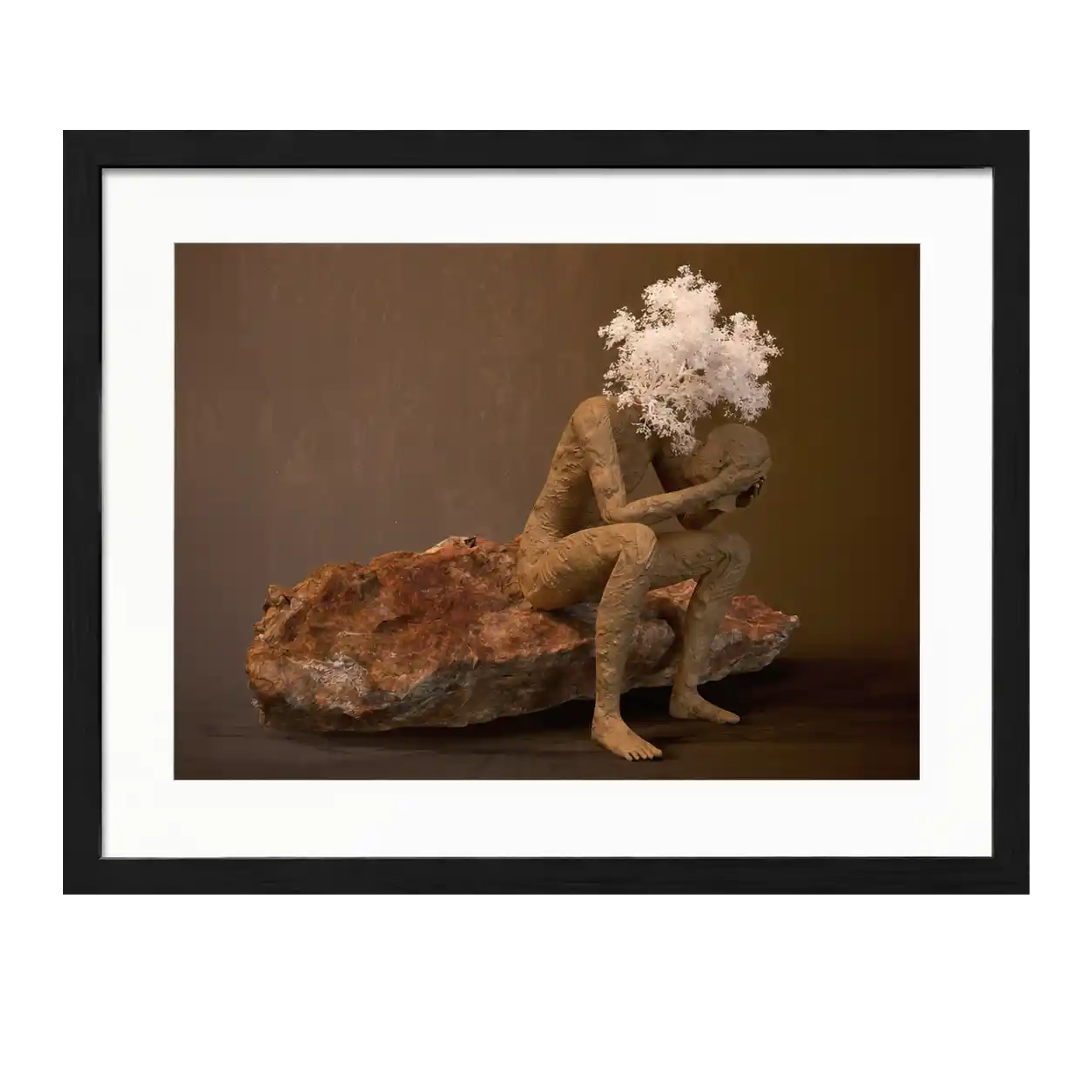 Digital sculpture of a seated figure on a rock holding its own head, with white tree branches rising above.