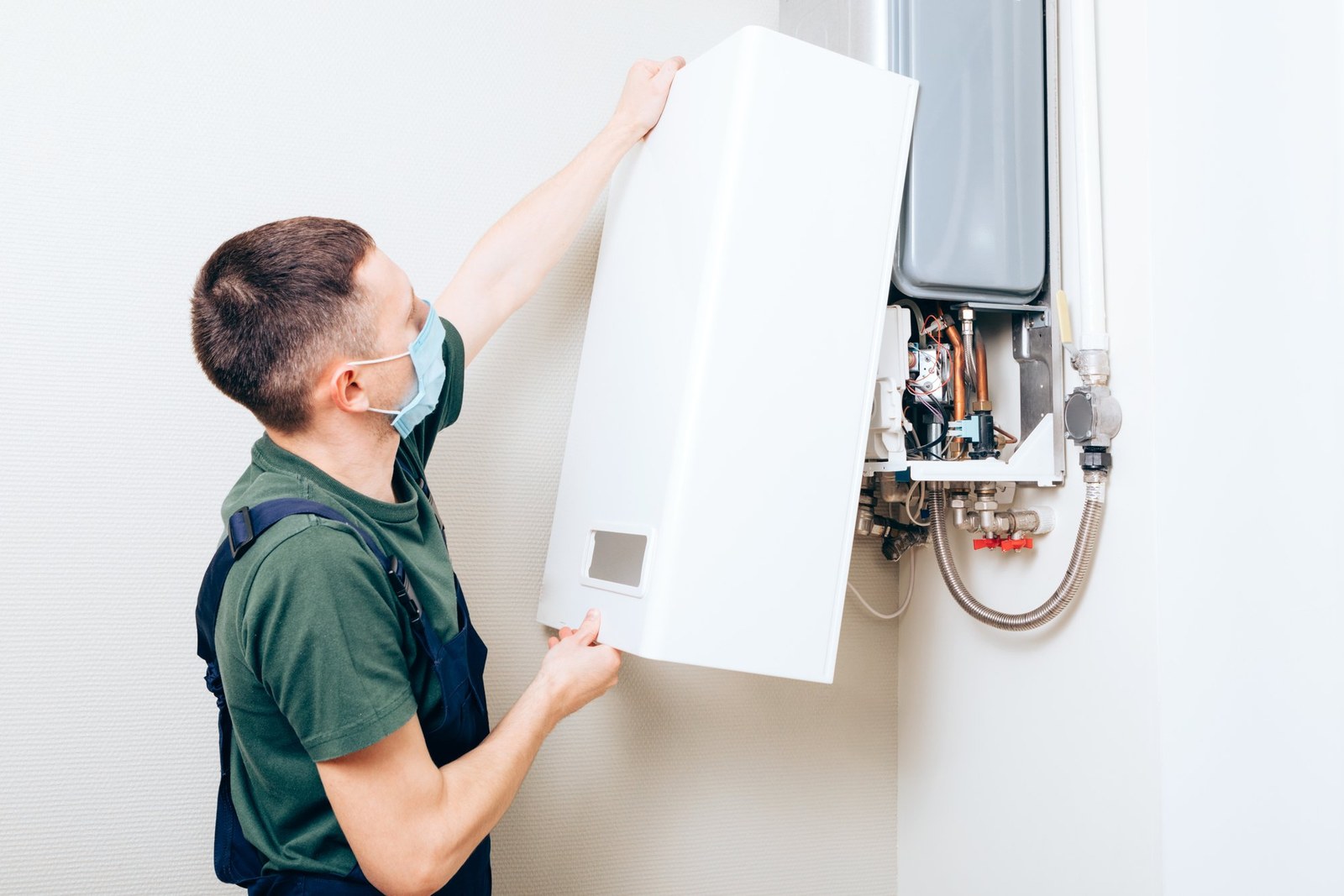 Gas boiler replacement – technician installing a new gas boiler on the wall – TorudeAbi24