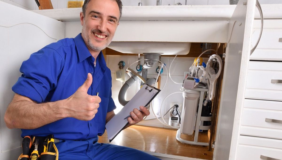 Emergency plumber from TorudeAbi24 fixing a leaking pipe in a Tallinn kitchen.