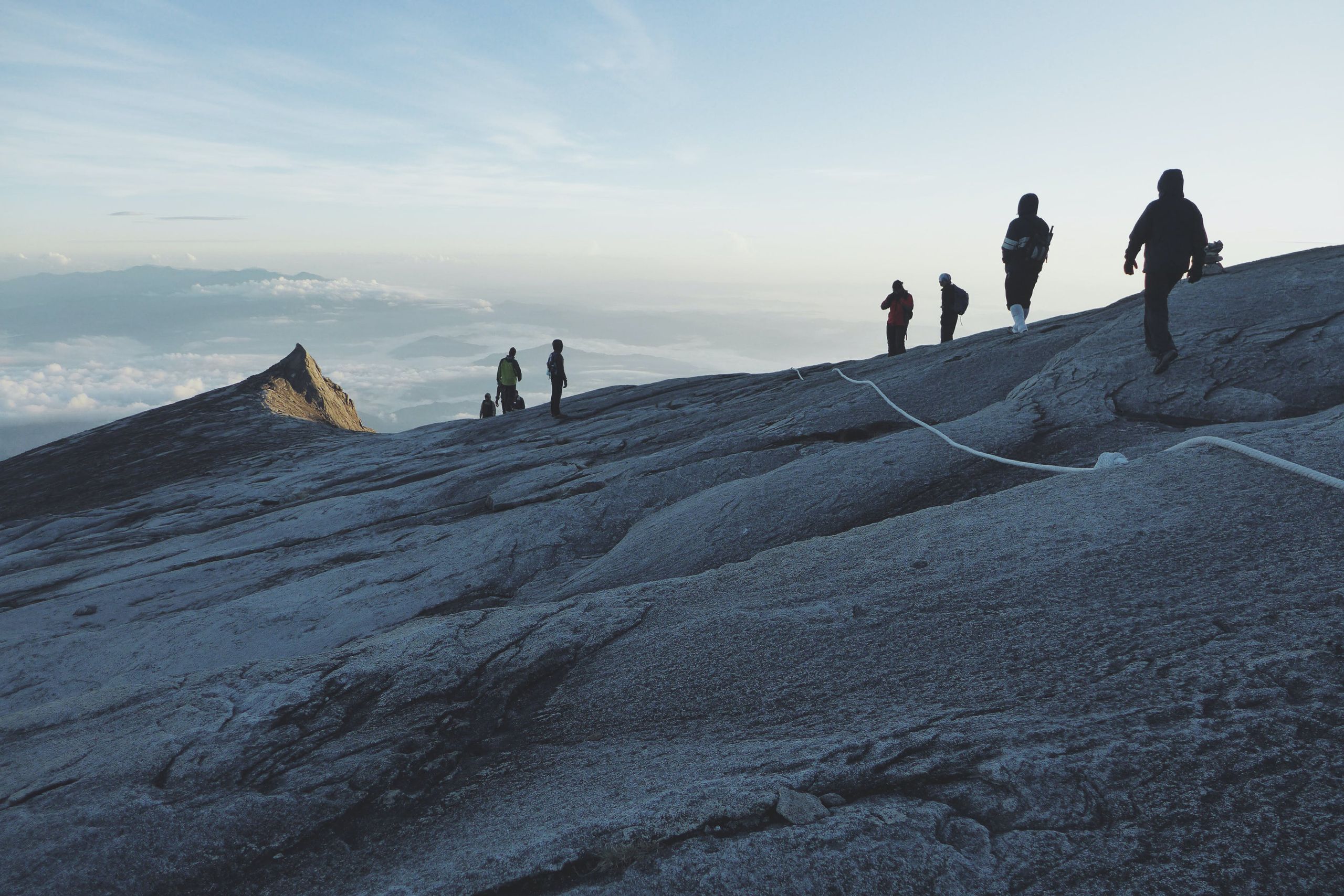 A team on top of the mountain looking over the sky