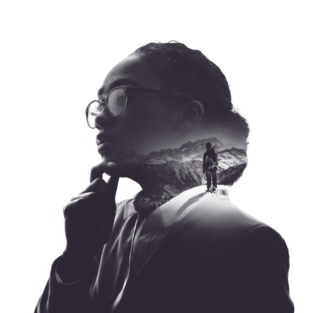 Double-exposure portrait of a woman in glasses, with a person on a mountain ridge inside her silhouette