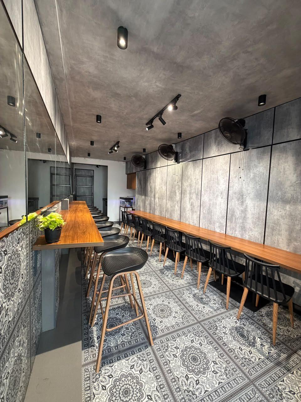 Pantry with wooden counters, black bar stools and patterned floor tiles