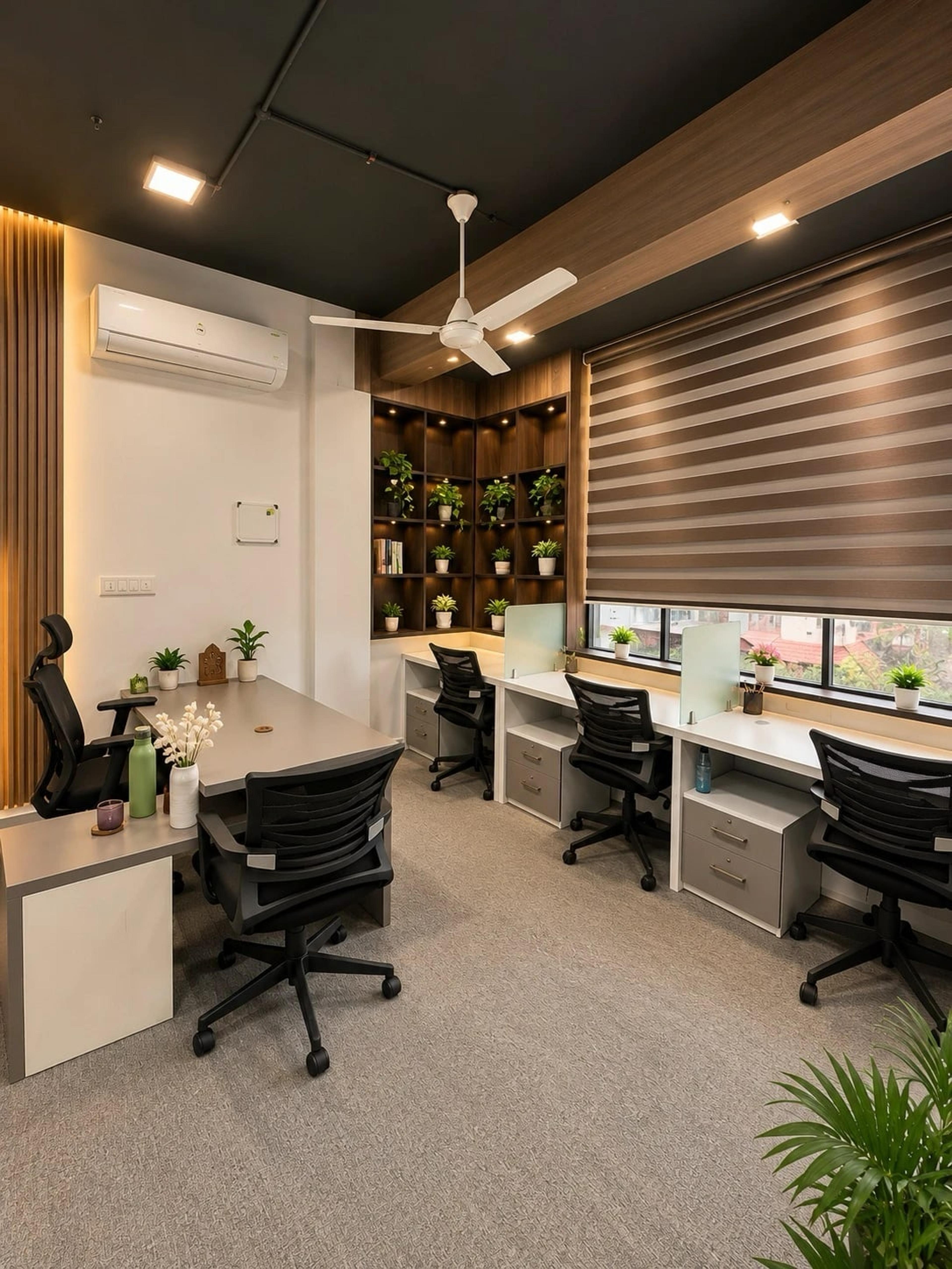Workspace with a manager desk, three workstations under a zebra blind, lit shelves with plants and a ceiling fan