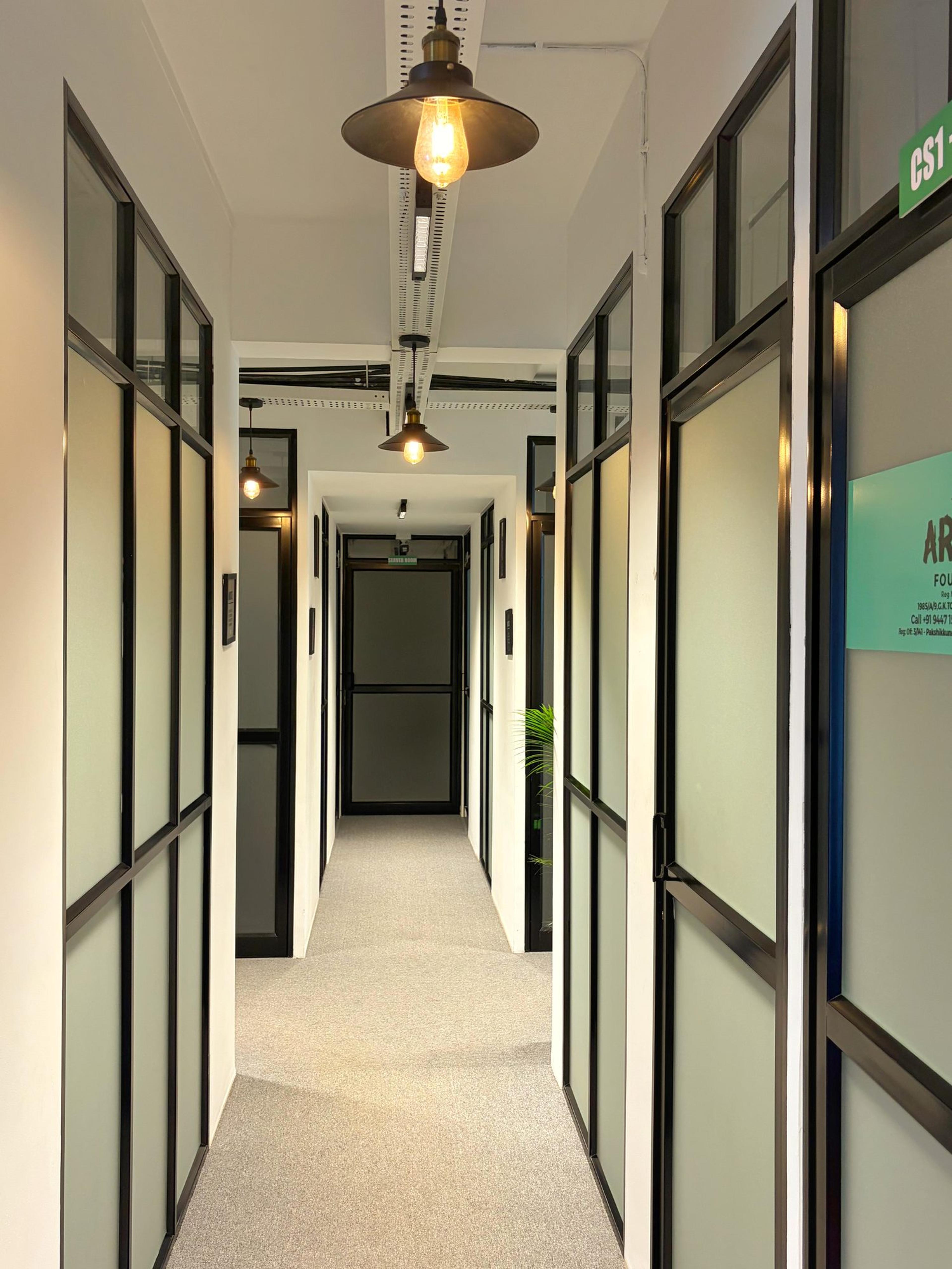 Long corridor of frosted-glass cabins under vintage pendant lights