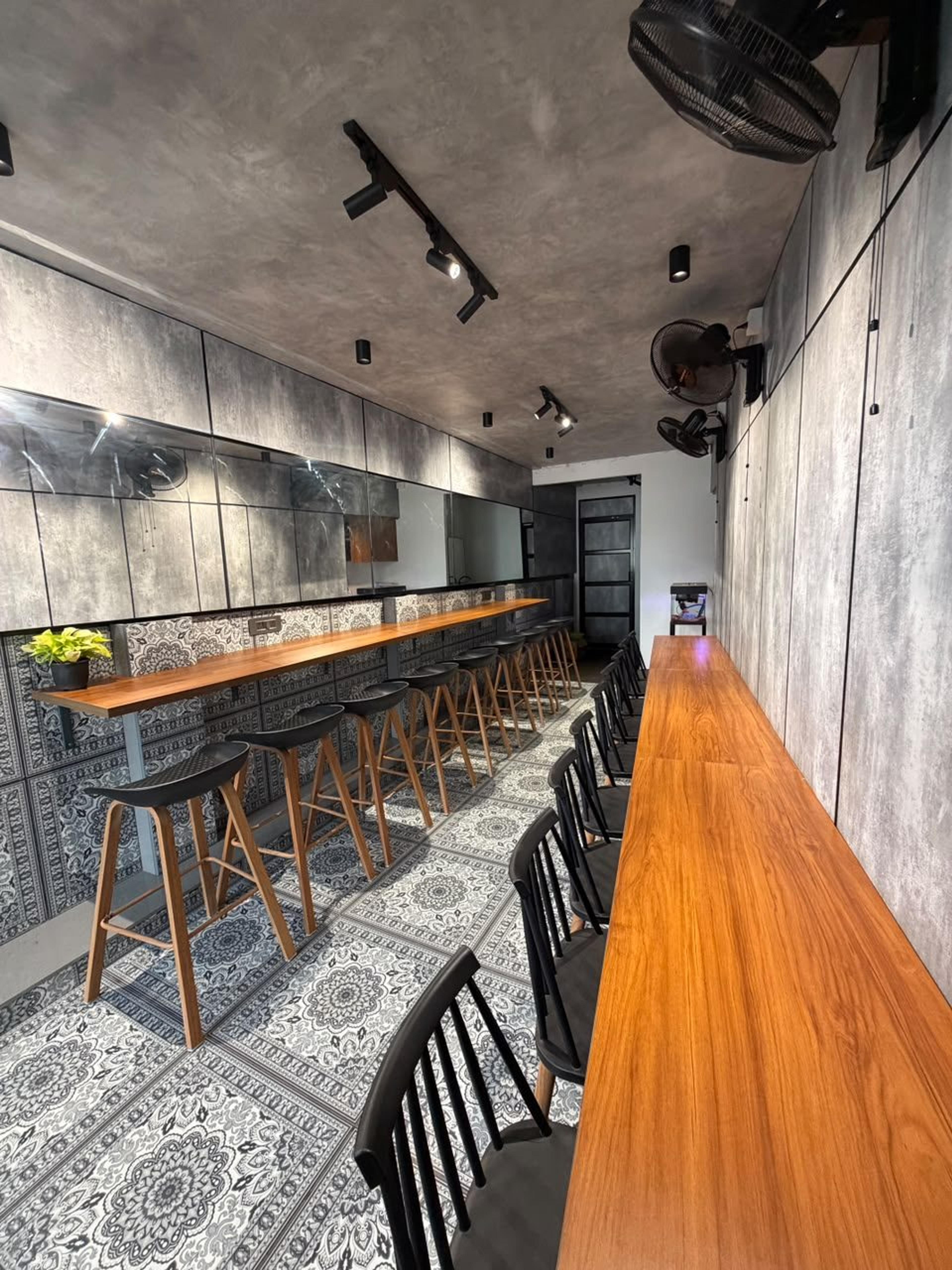 Pantry seating along wooden counters with spotlights and concrete-finish walls