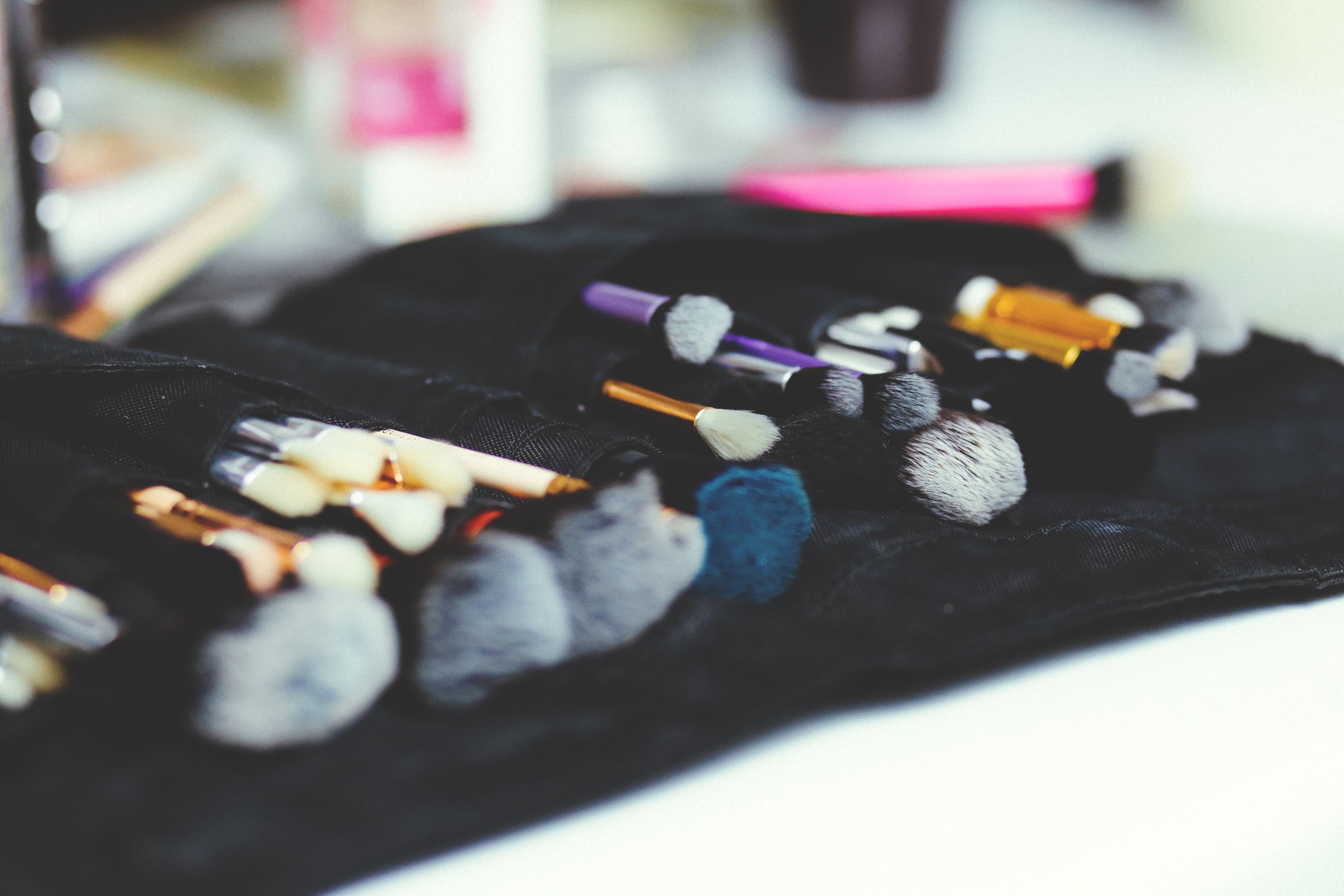 A roll of make-up brushes laid out on a black cloth