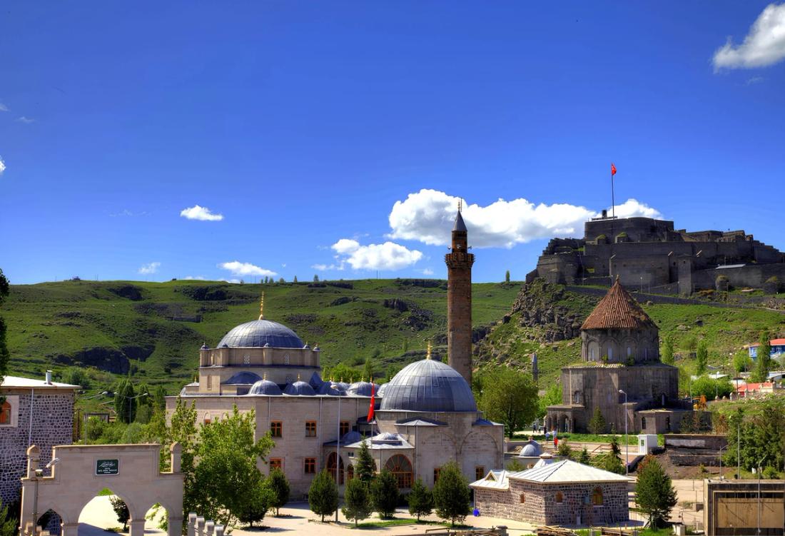 Kars'taki tarihi cami ve yapıların manzarası, mavi gökyüzü, Uluslararası Harakani Kültür Vakfı.