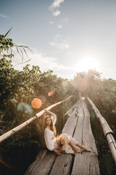 Mujer sentada en un puente posando para la cámara