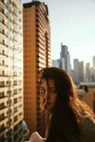 Mujer en un balcón  con el sol detrás siendo fotografiada