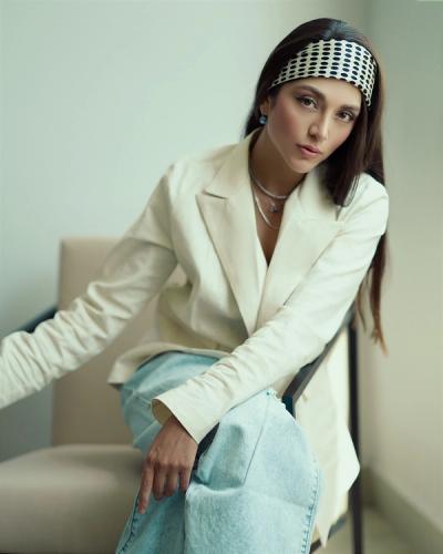 Mujer sentada de piernas cruzadas posando para la cámara