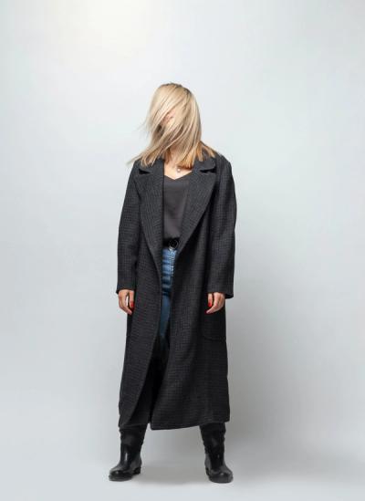 Mujer de pie con el cabello en el rostro posando para la cámara