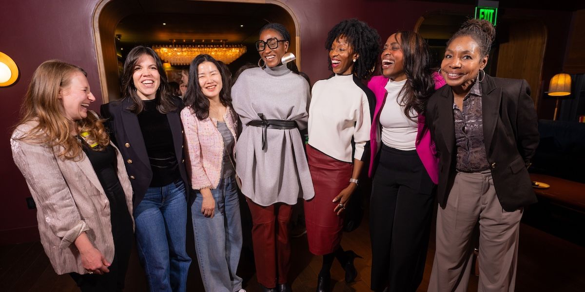 Seven members posing for the camera while mid-laugh